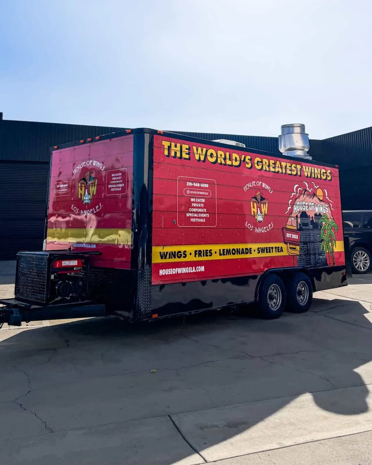 Rear three quarter of the trailer, showing the full wrap wrapping the corner and the catering details panel.